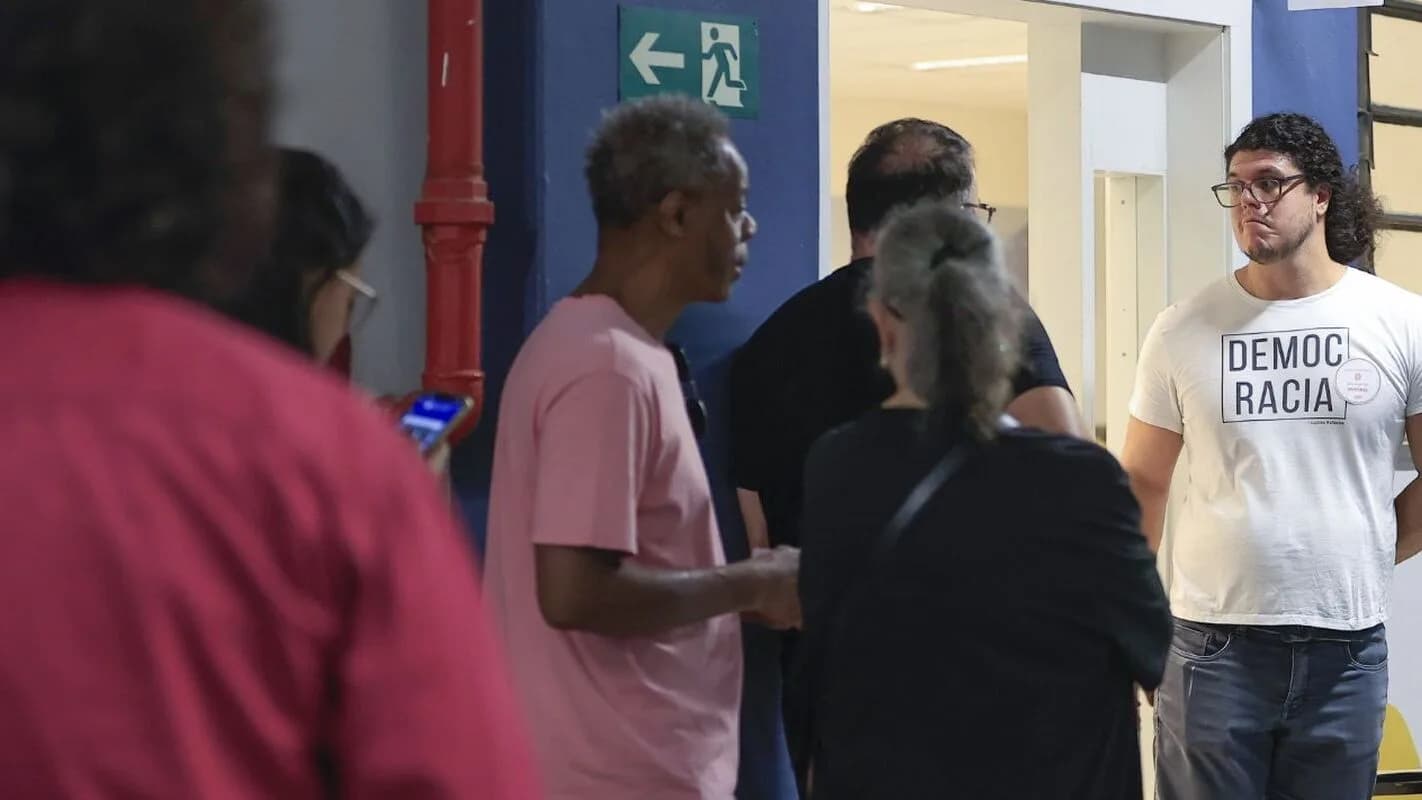 Eleitores conversam em fila de votação durante o primeiro turno de 2026