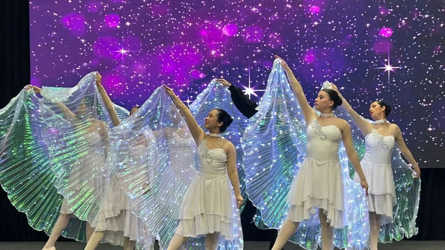 Grupo de dança formado por pessoas com deficiência visual se apresenta em palco (foto de contexto)