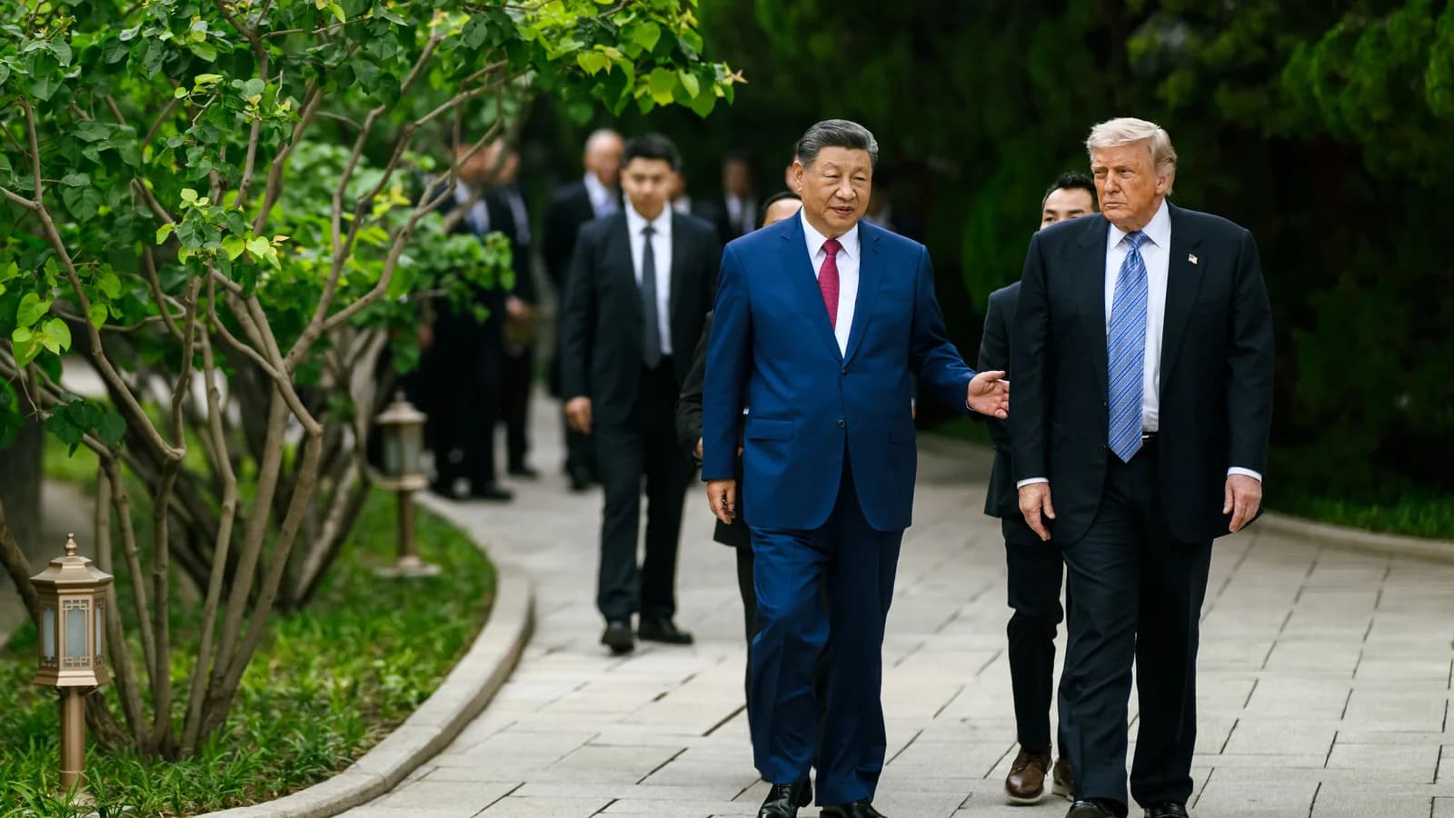 Xi Jinping e Donald Trump caminham lado a lado durante encontro diplomático.