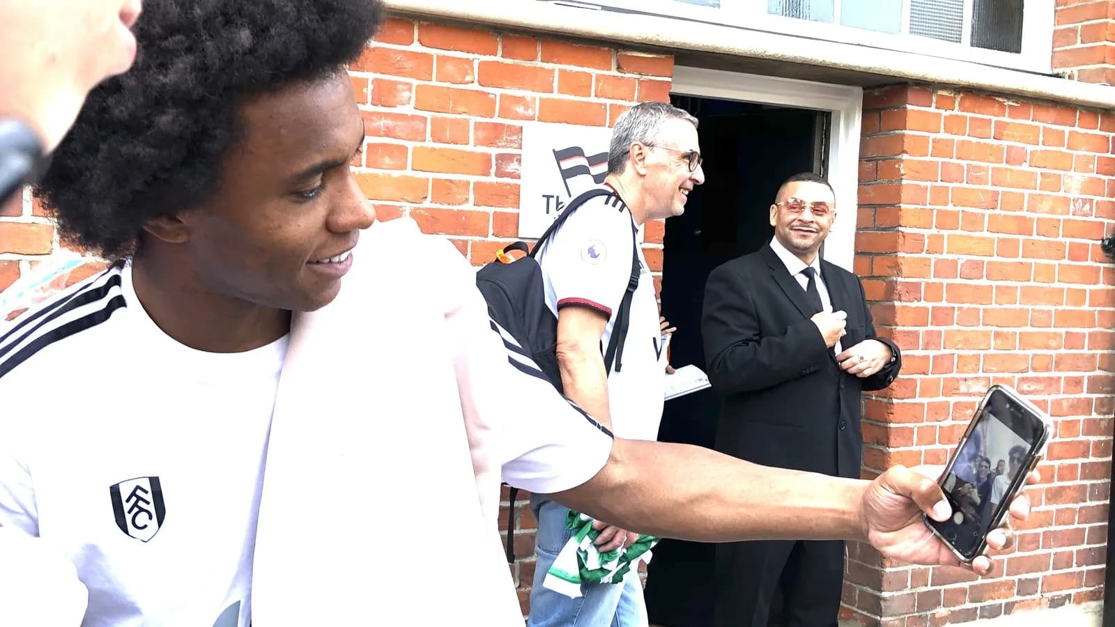 Willian cumprimenta torcedores do lado de fora de um estádio na Inglaterra