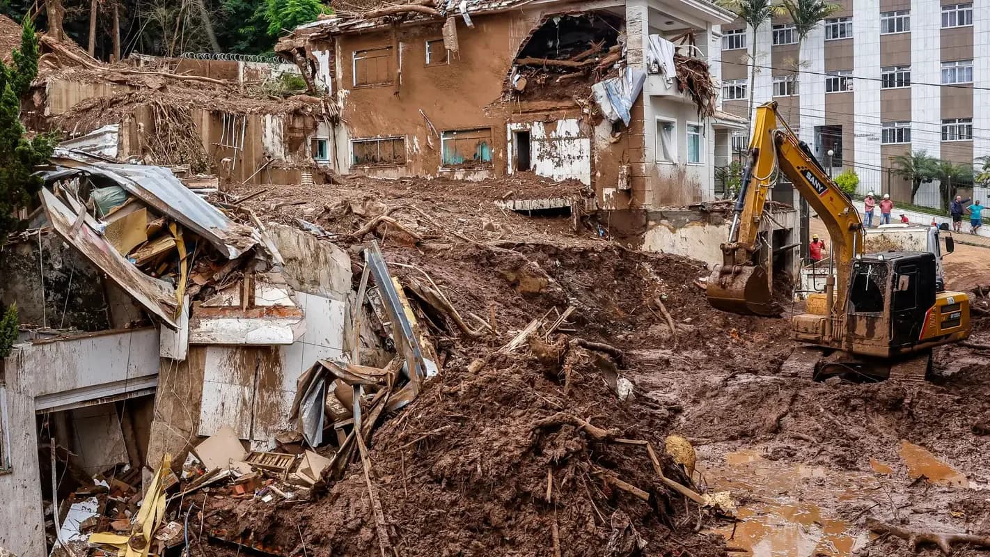 Escavadeira remove escombros de casa destruída pela enchente na Zona da Mata mineira