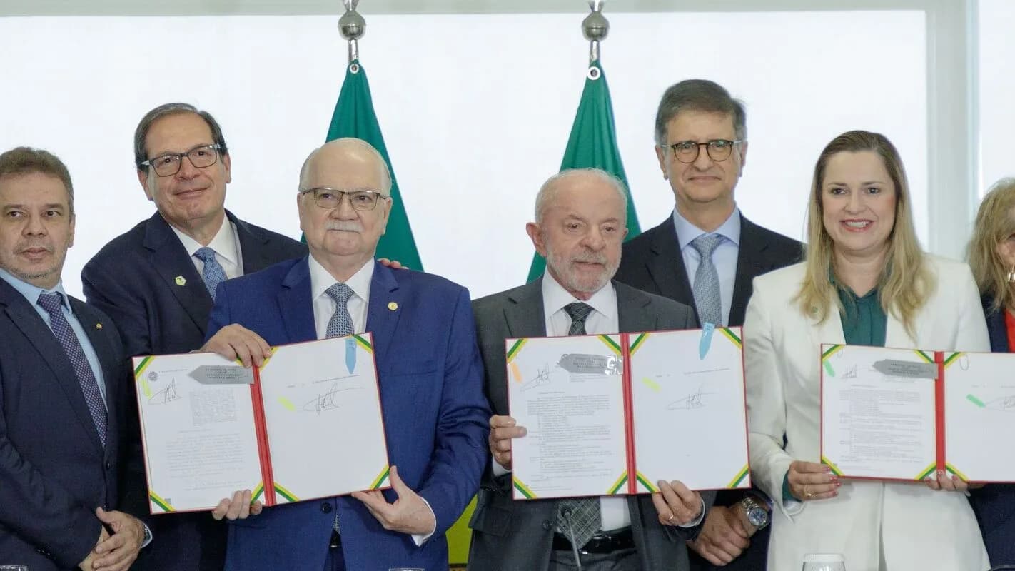 Lula sorri ao lado de autoridades durante cerimônia de sanção de leis no Palácio do Planalto