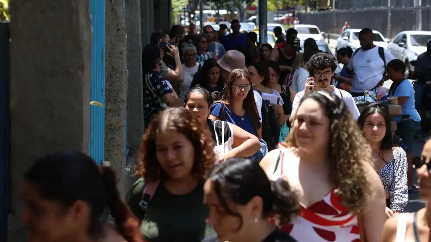 Candidatos caminham em fila para prova de concurso público em foto de arquivo ilustrativa