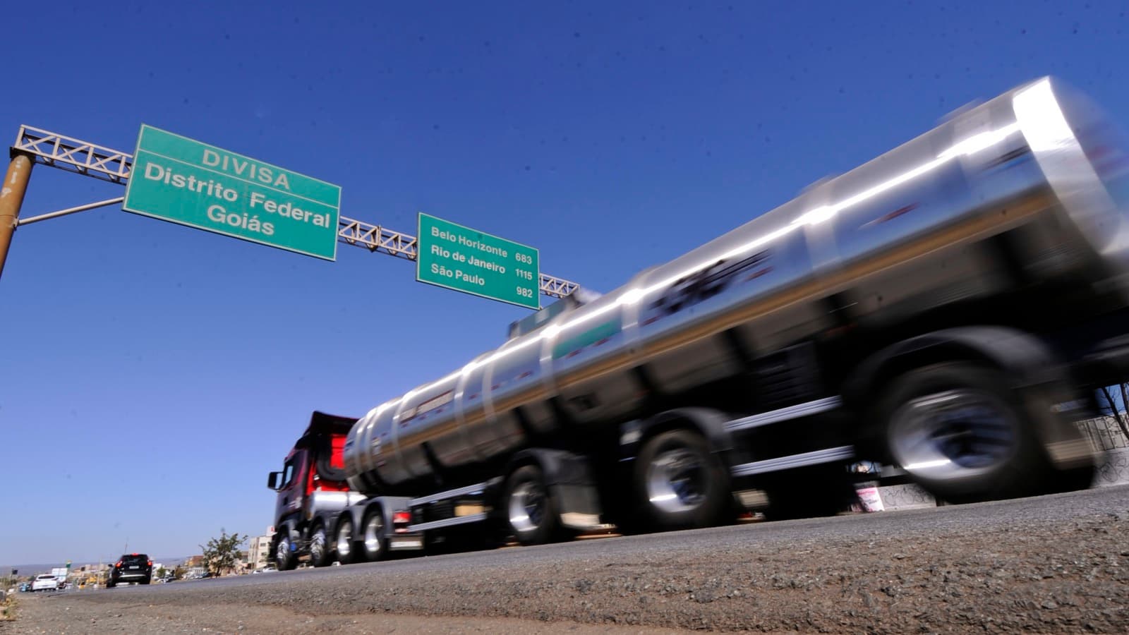 Foto de arquivo mostra um caminhão-tanque passando em rodovia sob placa que indica a divisa entre o Distrito Federal e Goiás, com outros veículos ao fundo