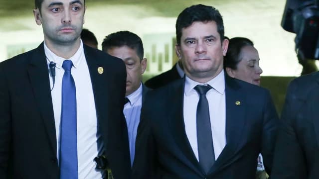 O senador Sergio Moro caminha ao lado de assessores em corredor de prédio público (foto de arquivo)