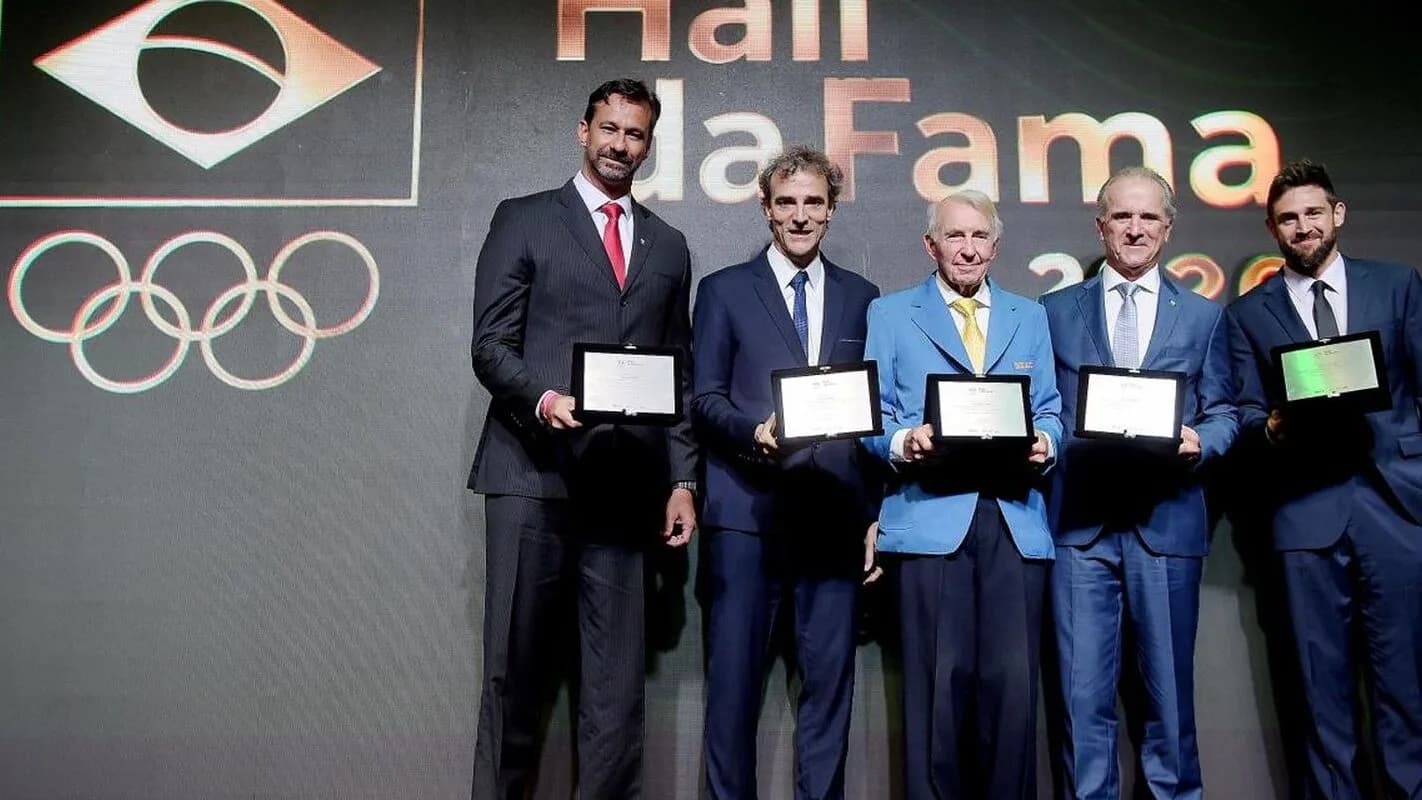 Cerimônia do Hall da Fama do COB com homenageados segurando placas no palco