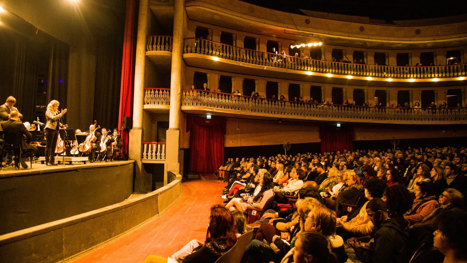 Orquestra sinfônica se apresenta em teatro lotado