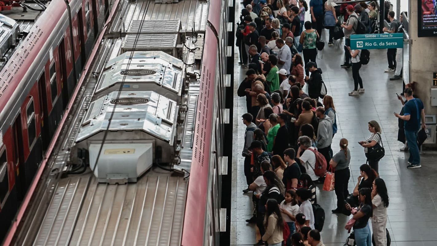 Plataforma lotada de passageiros aguardando trem ao lado de composição da CPTM em estação de São Paulo