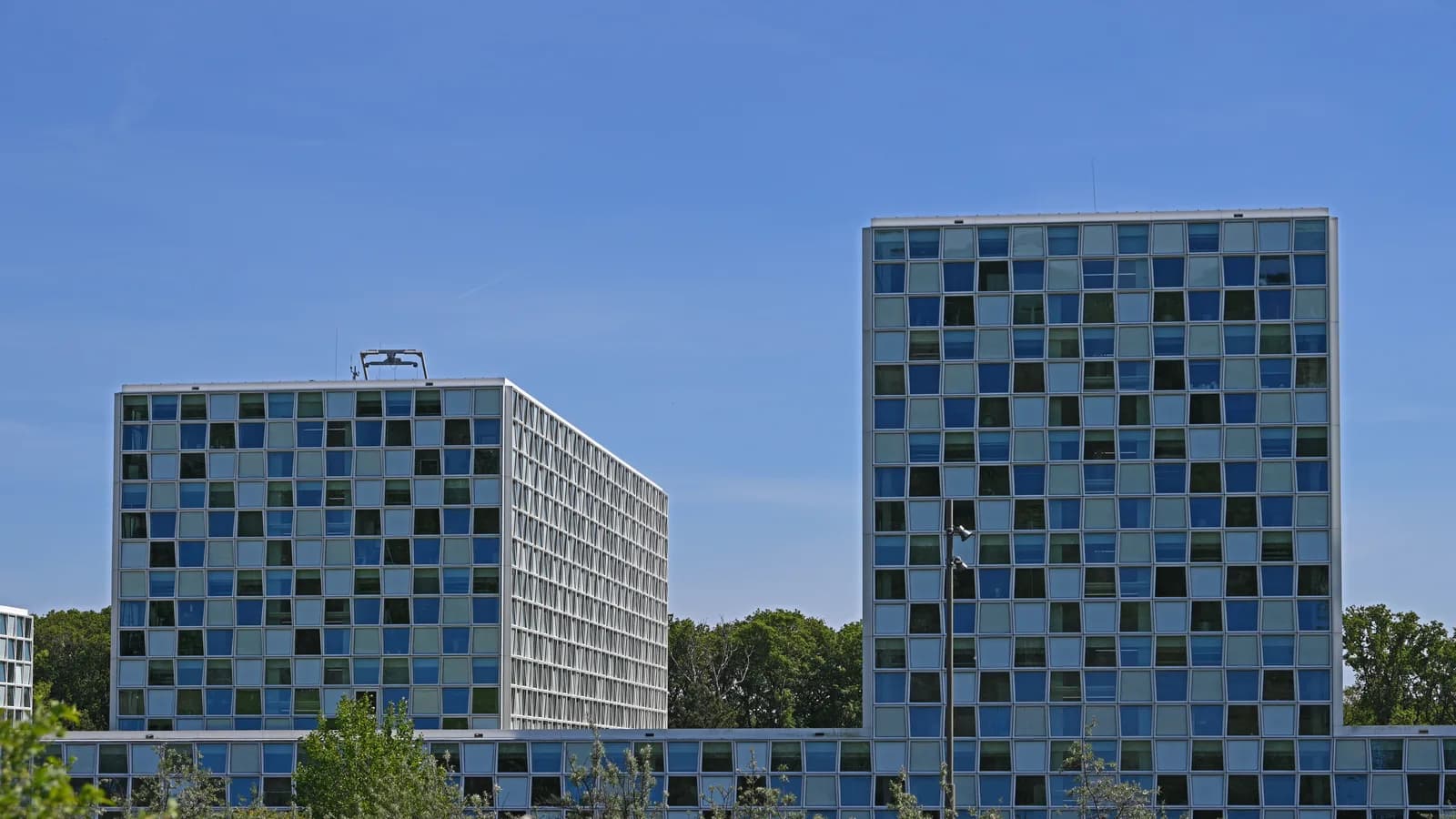 Sede do Tribunal Penal Internacional em Haia, na Holanda, vista de fora em dia de céu aberto.