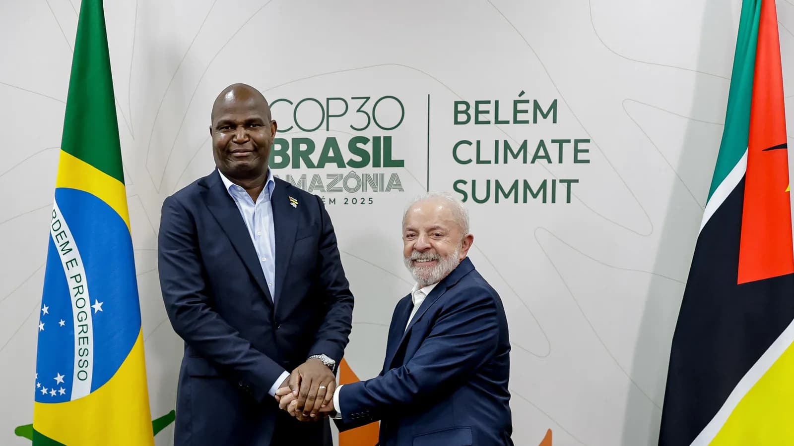 Daniel Chapo aperta a mão de Lula em reunião bilateral, com as bandeiras do Brasil e de Moçambique ao fundo