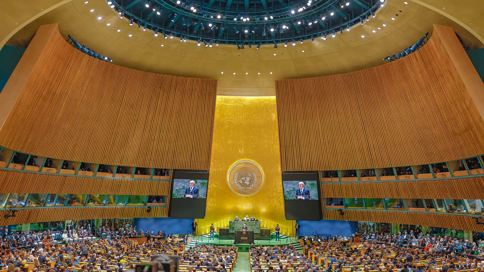 Plenário da Assembleia Geral da ONU em Nova York durante discurso de abertura, com telões mostrando o orador
