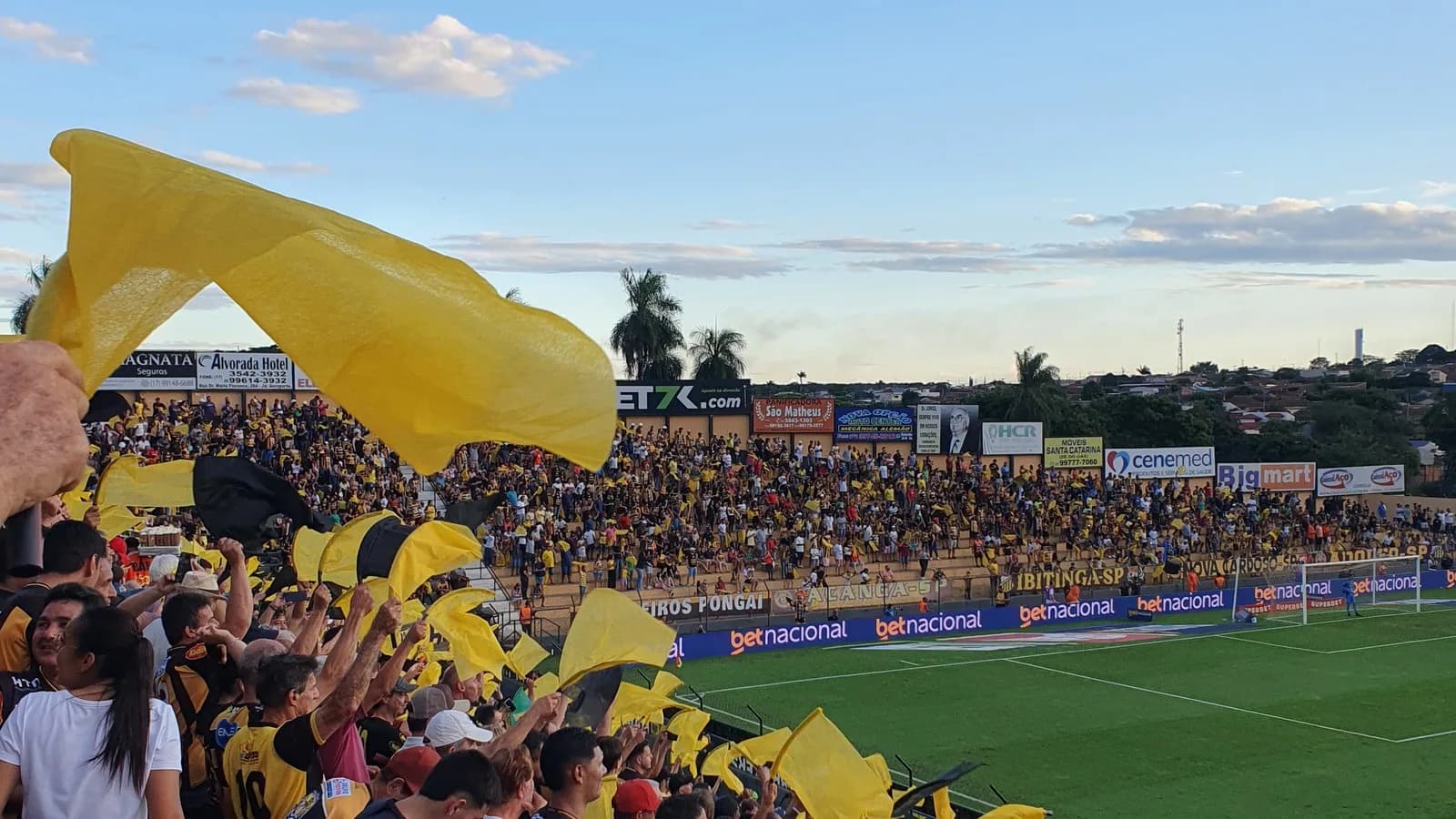 Torcida do Paysandu com bandeiras nas cores do clube em arquibancada