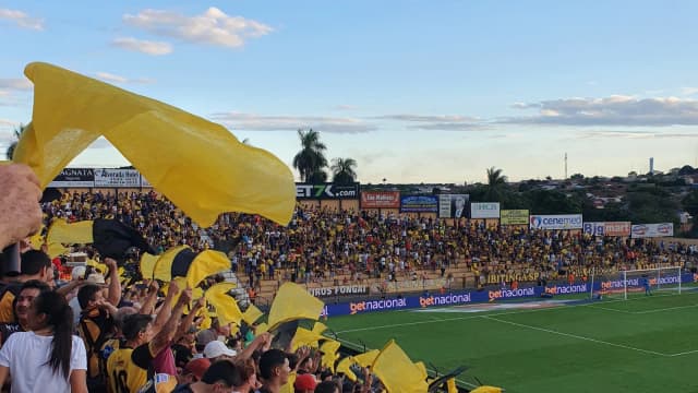 Torcida do Paysandu com bandeiras nas cores do clube em arquibancada