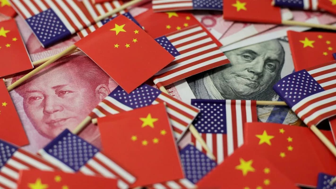 Bandeirinhas dos Estados Unidos e da China sobre notas de dólar e de iuane