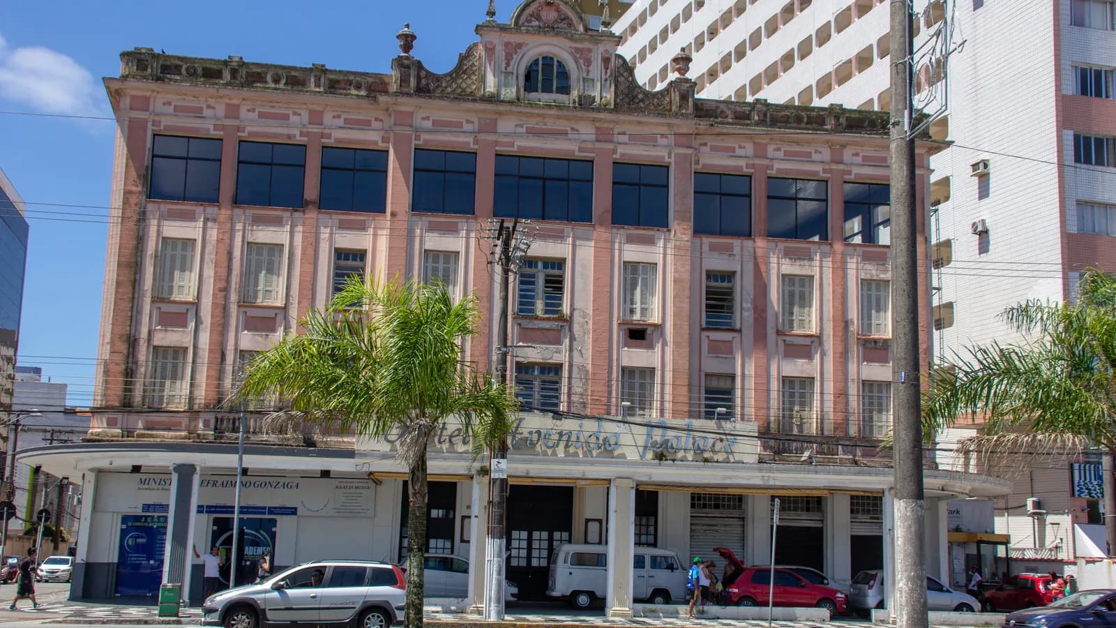 Rua do centro histórico de Santos (SP), com prédio antigo e movimento de carros
