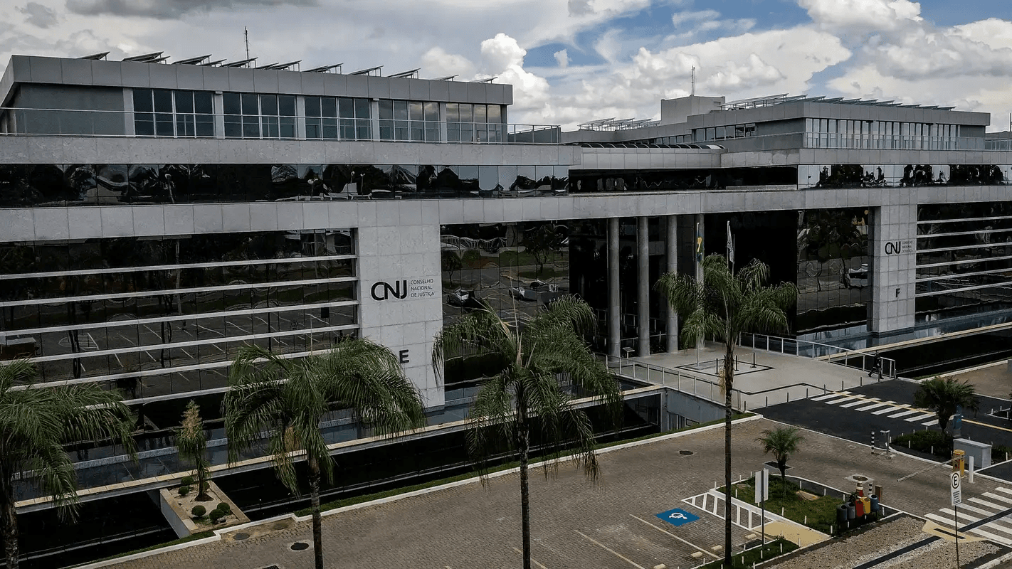 Fachada do prédio do Conselho Nacional de Justiça (CNJ) em Brasília, com palmeiras em primeiro plano