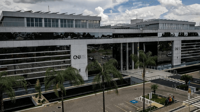 Fachada do prédio do Conselho Nacional de Justiça (CNJ) em Brasília, com palmeiras em primeiro plano