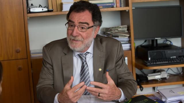 Deputado Patrus Ananias concede entrevista em seu gabinete, com estante de livros ao fundo