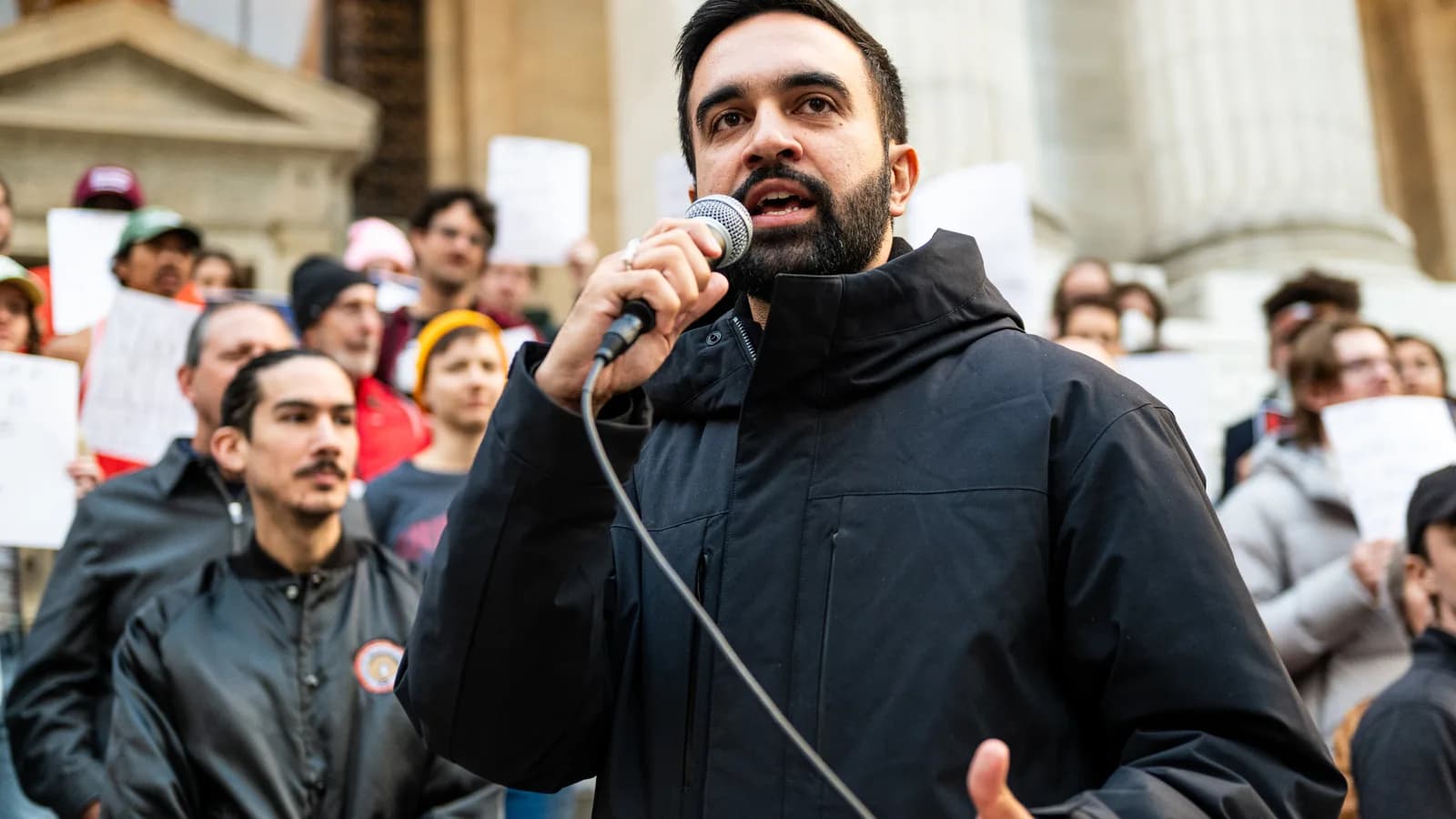 Zohran Mamdani discursa ao microfone em ato público em Nova York
