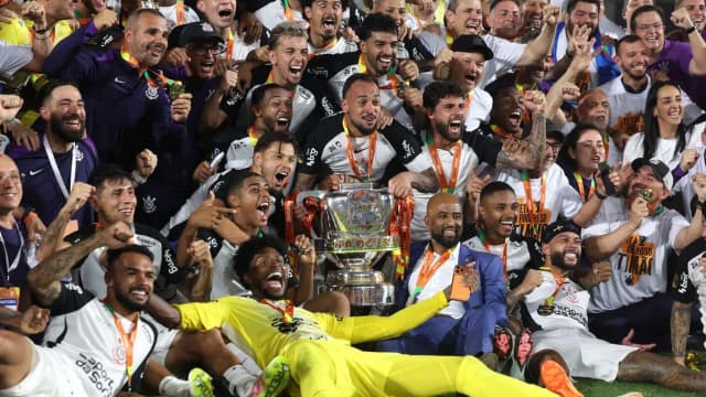 Jogadores do Corinthians comemoram com troféu em campo