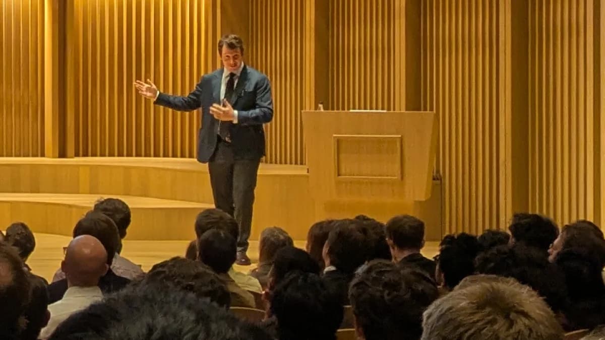 Jack Clark, cofundador da Anthropic, gesticula ao discursar em auditório lotado