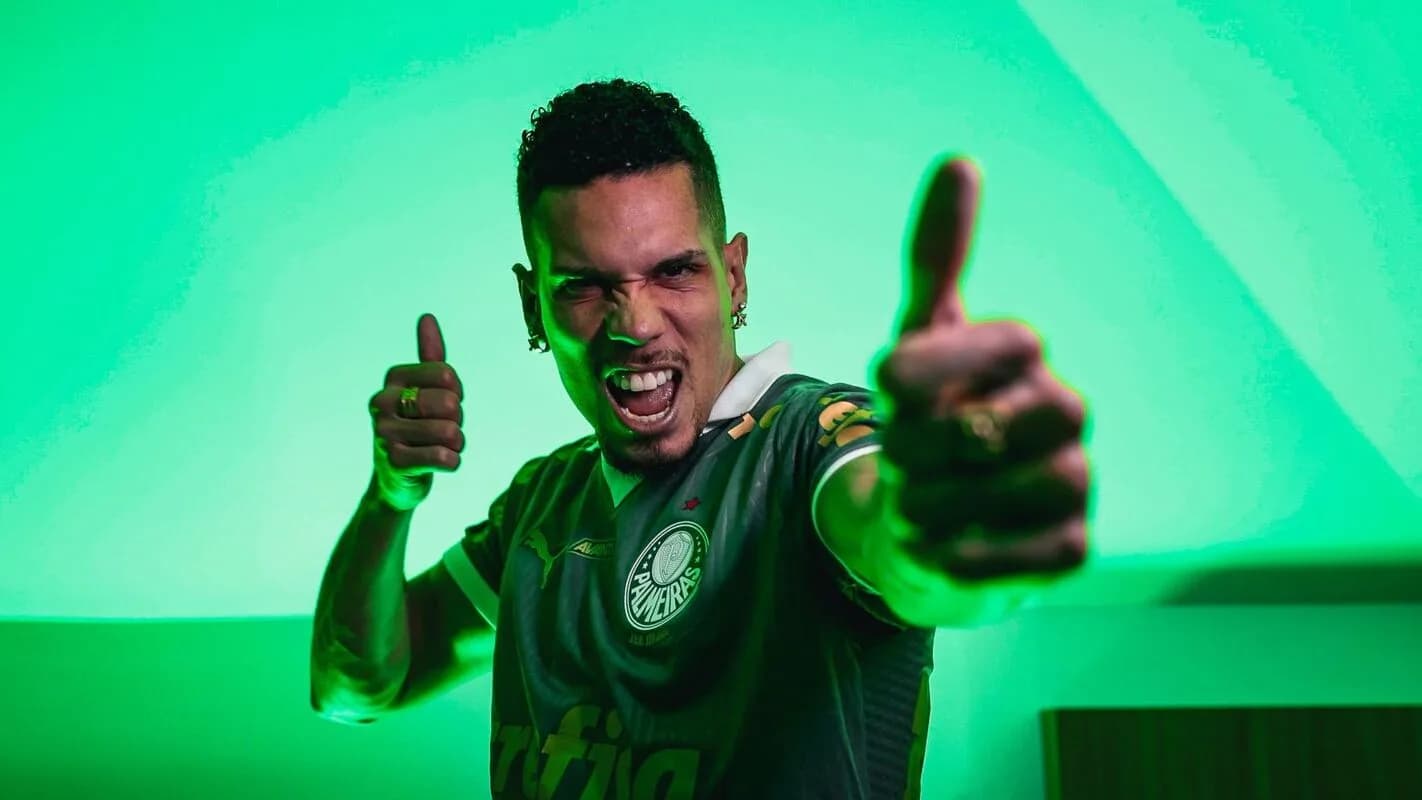 Paulinho comemora com as duas mãos erguidas, vestindo o uniforme do Palmeiras