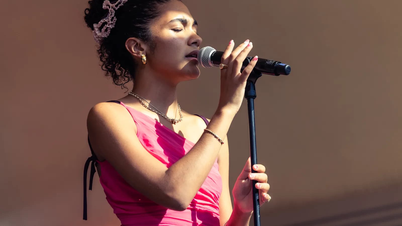 Olivia Dean canta ao microfone durante apresentação ao vivo