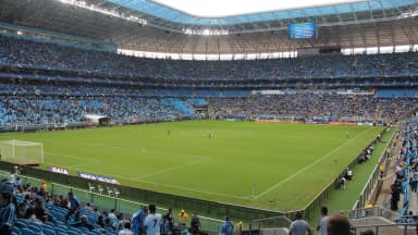Arena do Grêmio lotada durante partida, com torcida nas arquibancadas