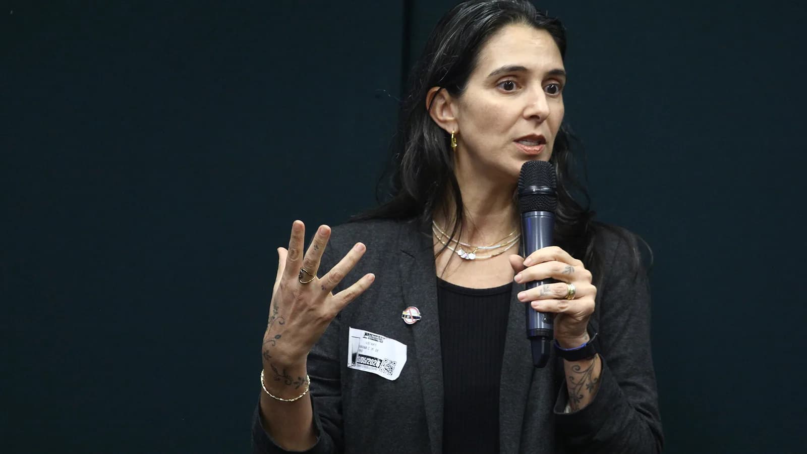 Mulher fala ao microfone em audiência pública sobre pacientes com câncer, na Câmara dos Deputados