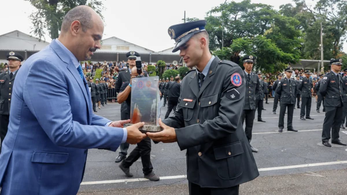 Oficial do Corpo de Bombeiros Militar de Minas Gerais recebe placa de autoridade civil durante cerimônia oficial