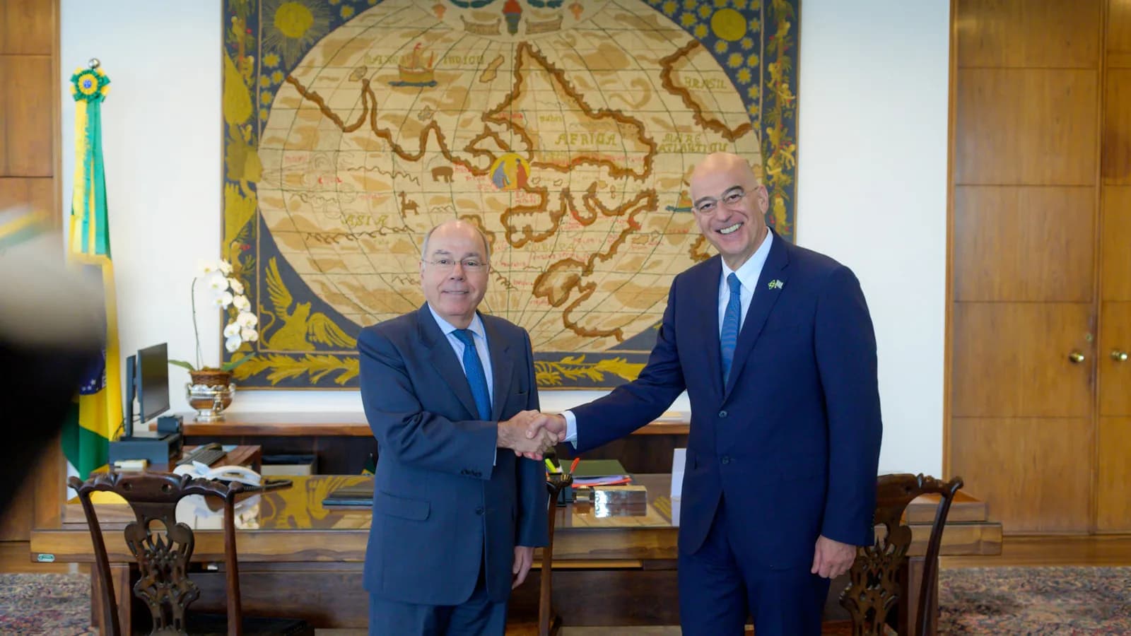 Chanceler Mauro Vieira cumprimenta autoridade em seu gabinete, com bandeira do Brasil ao fundo