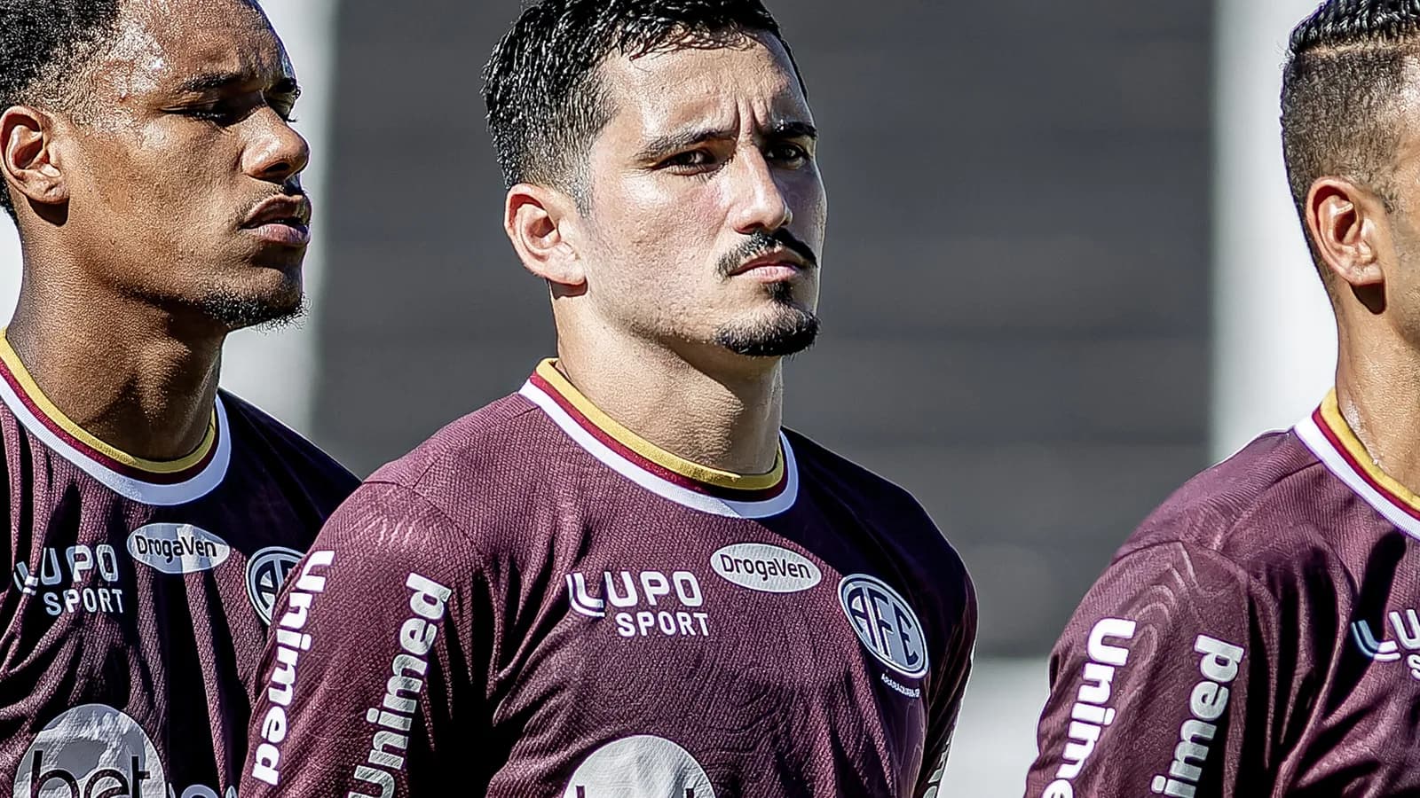 Jogadores da Ferroviária reunidos antes de partida, vestindo uniforme grená
