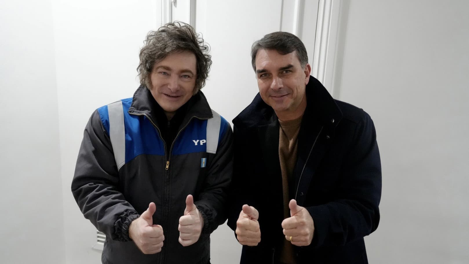 Javier Milei e Flávio Bolsonaro lado a lado, ambos fazendo sinal de positivo, em encontro de junho de 2026 (foto de arquivo)