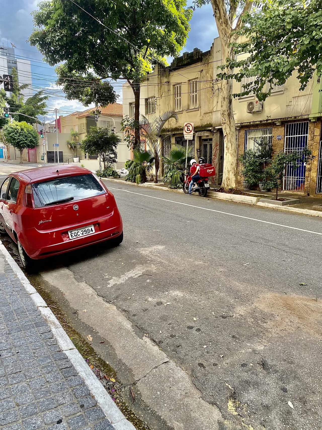 No bairro de Santa Cecília, rua Tupi, um casal se reúne em uma moto para deixar uma entrega do aplicativo Ifood na portaria de uma casa - Fotografia realizada no contexto de um pro
