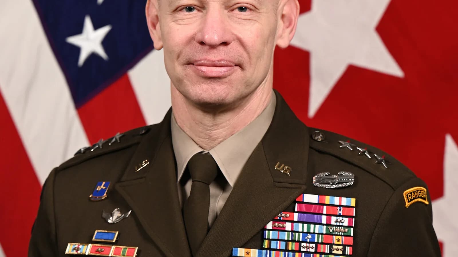 Retrato oficial do tenente-general Brett Sylvia, do Exército dos Estados Unidos, em frente a bandeiras americanas