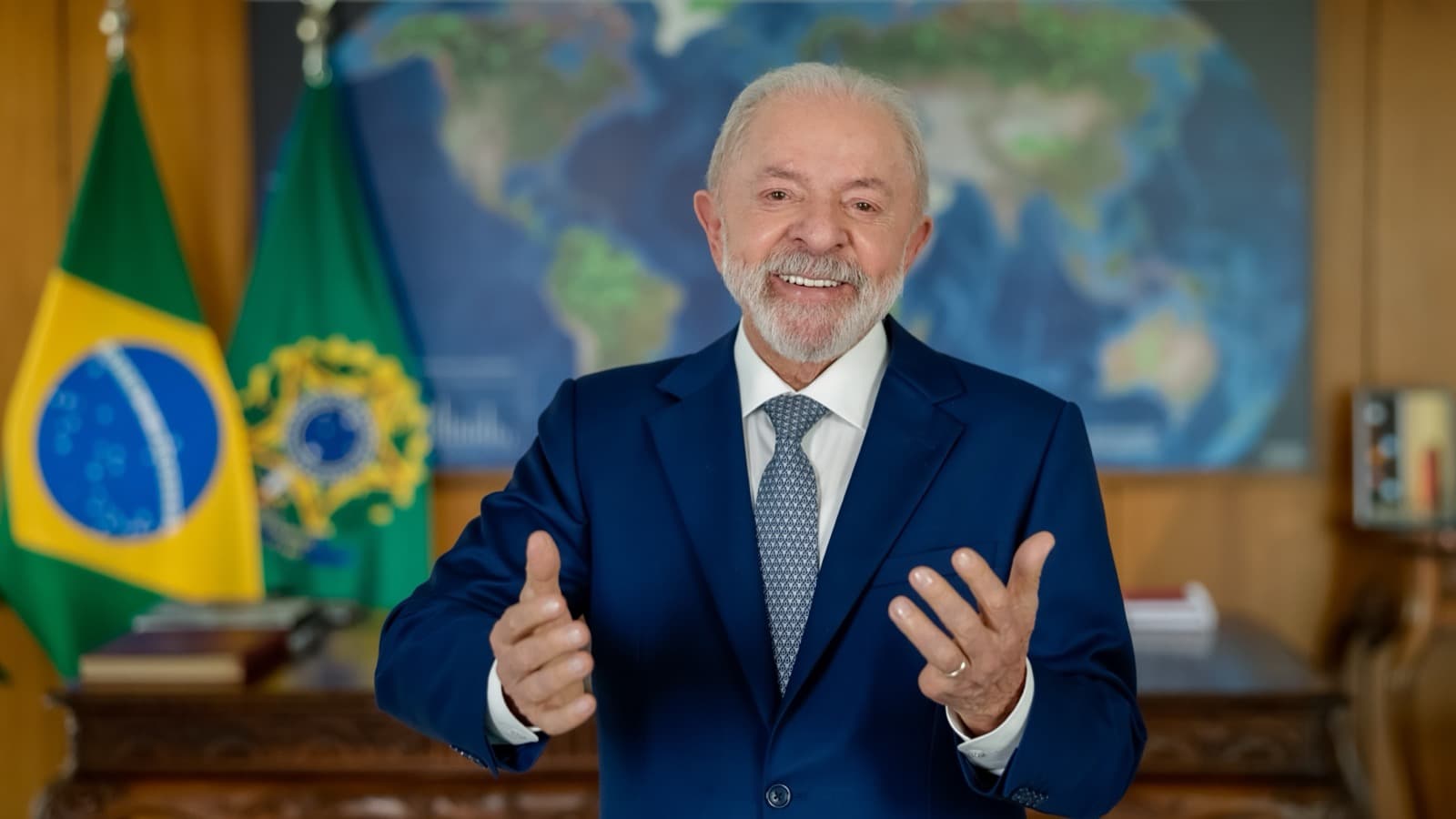 O presidente Luiz Inácio Lula da Silva, de terno azul, gesticula ao falar diante das bandeiras do Brasil e da Presidência da República, em foto de arquivo de novembro de 2025