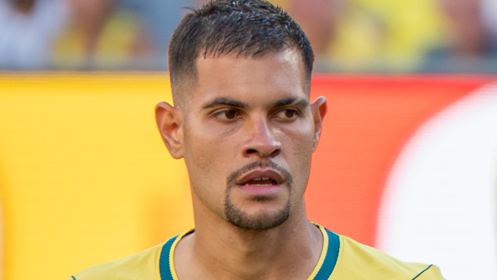 O meio-campista Bruno Guimarães de perfil, com a camisa amarela da Seleção Brasileira, em imagem de arquivo