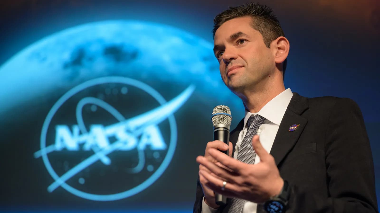 Jared Isaacman, administrador da Nasa, fala em evento com o logo da agência ao fundo