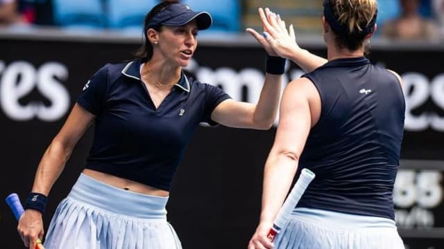 Luisa Stefani e Gabriela Dabrowski comemoram ponto com as mãos levantadas durante partida de duplas