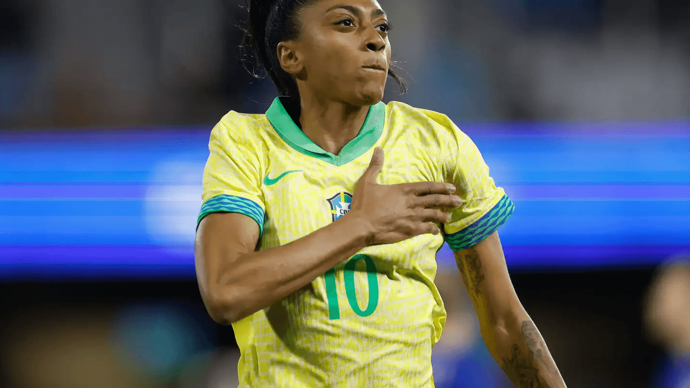 Kerolin comemora com a mão no peito vestindo a camisa amarela da seleção brasileira