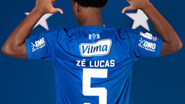 Zé Lucas posa de costas com a camisa 5 do Cruzeiro, com seu nome estampado, no dia de sua apresentação