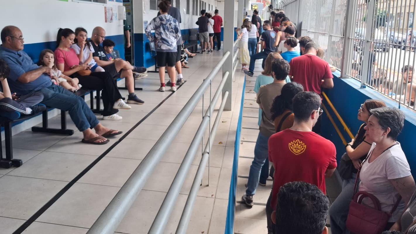 Fila de pessoas, incluindo crianças, em posto de saúde de São Paulo à espera da vacina contra o sarampo