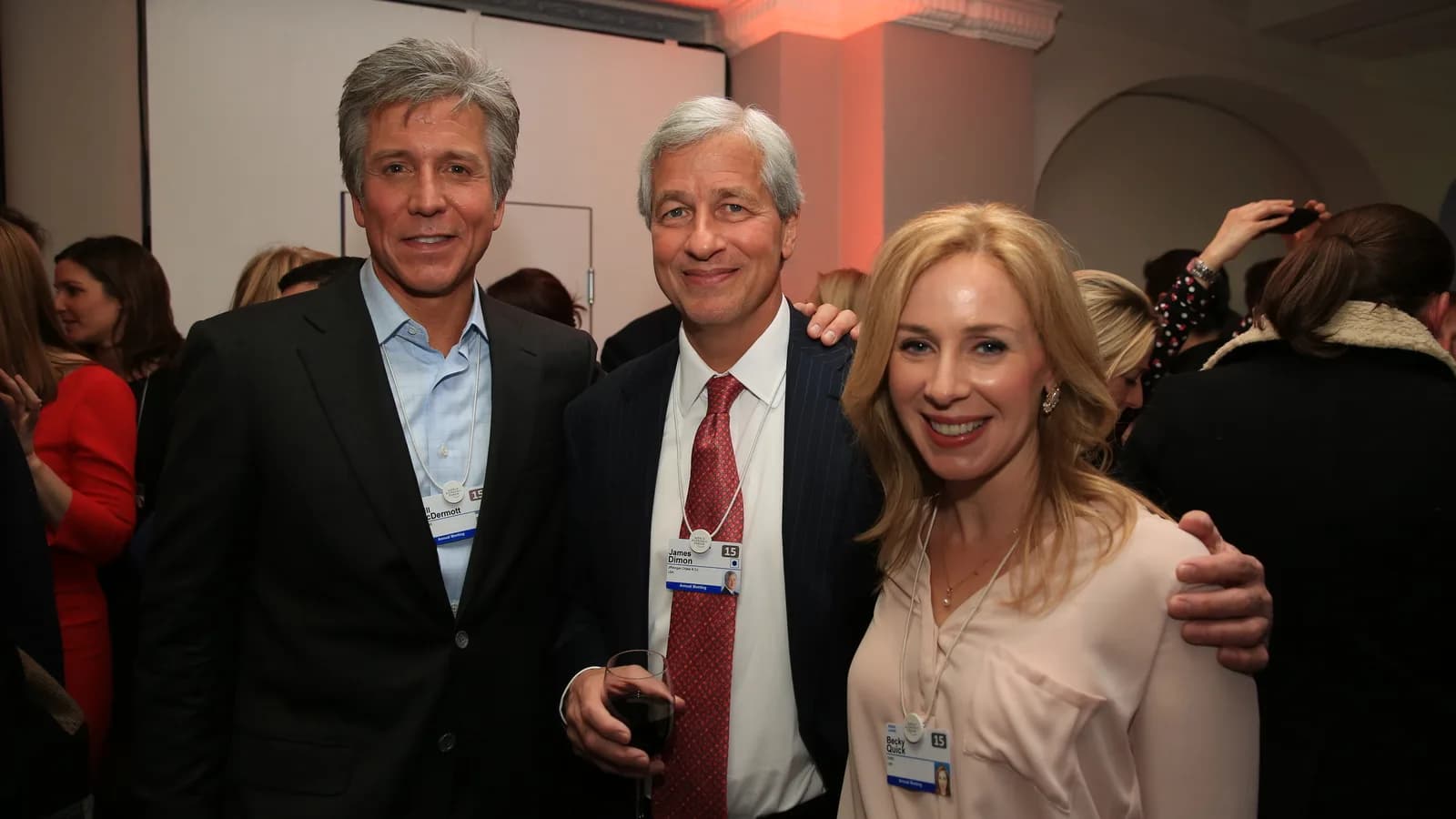Jamie Dimon, CEO do JPMorgan, sorri ao lado de outras duas pessoas em evento