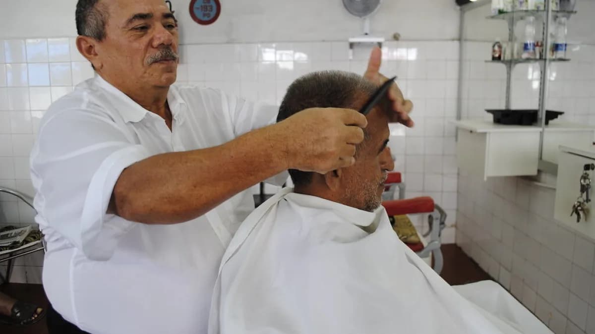 Barbeiro corta o cabelo de um cliente em barbearia (foto ilustrativa)