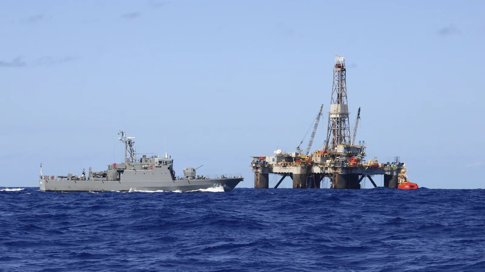 Navio-patrulha da Marinha do Brasil navega perto de plataforma de petróleo em alto-mar