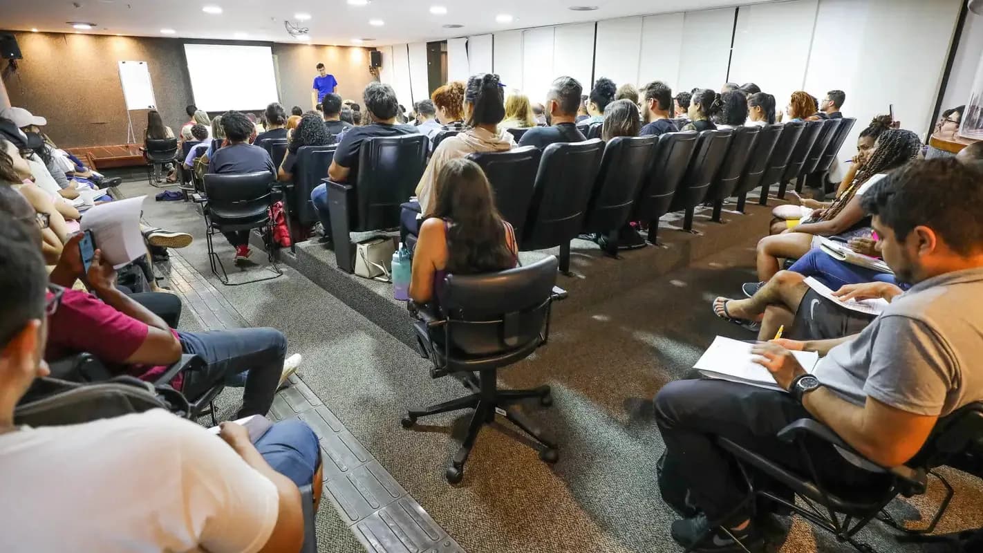 Candidatos sentados em auditório durante aula preparatória para concurso público, foto de arquivo