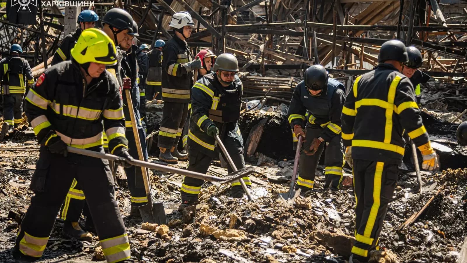 Bombeiros do Serviço Estadual de Emergência da Ucrânia trabalham em meio a escombros após ataque russo em Kharkiv