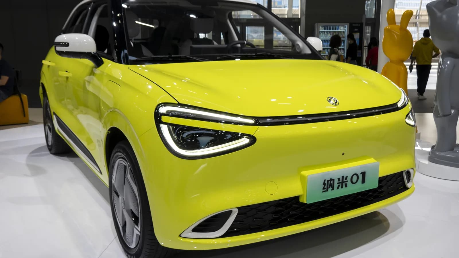 Hatch elétrico amarelo DFM Box, vendido na China como Nammi 01, exposto em feira automotiva