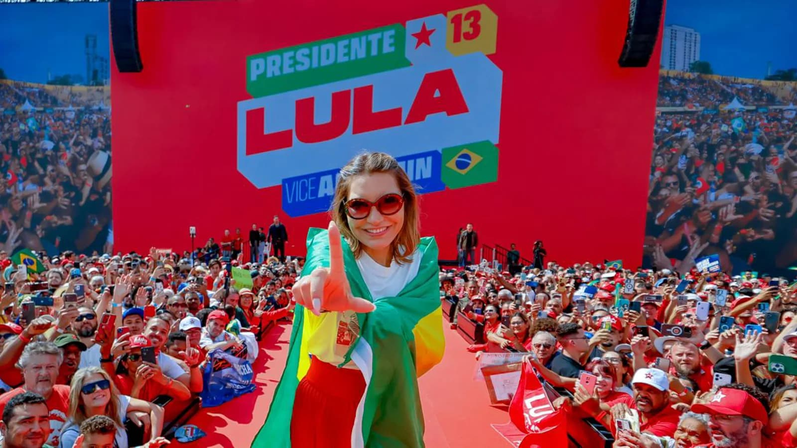 Multidão em comício com bandeira de apoio a Lula durante lançamento da campanha presidencial de 2026