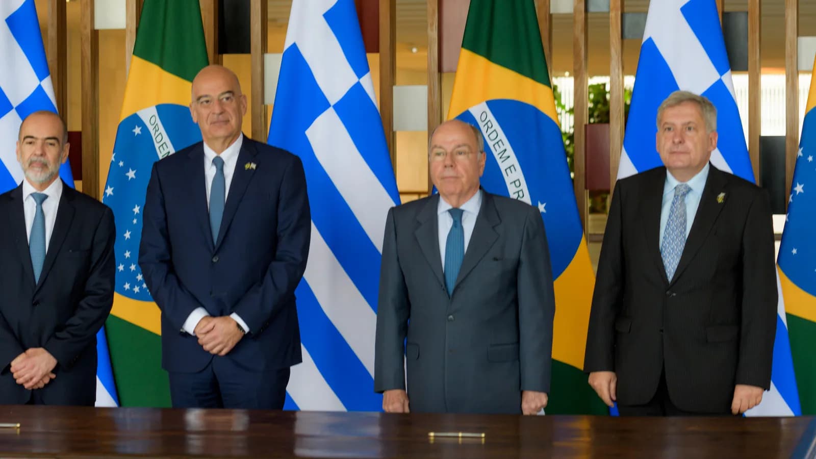 O chanceler Mauro Vieira em reunião diplomática com autoridades estrangeiras, diante das bandeiras do Brasil e do país anfitrião